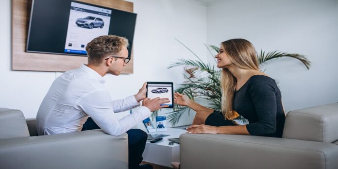 Man and woman in a car showroom using tablet Automotive SEO Agency